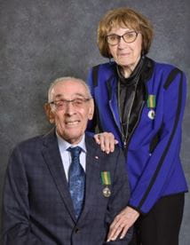 Audrey and Ron Euteneier, wearing formal attire with the Saskatchewan Volunteer Medal pinned to their suit jackets. 