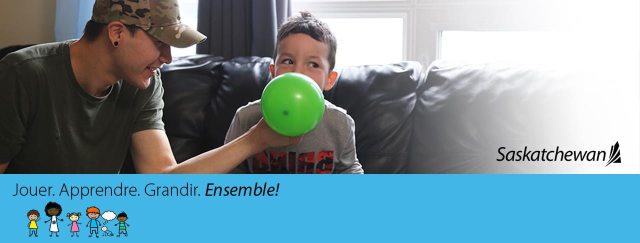 Papa aidant son fils à gonfler un ballon