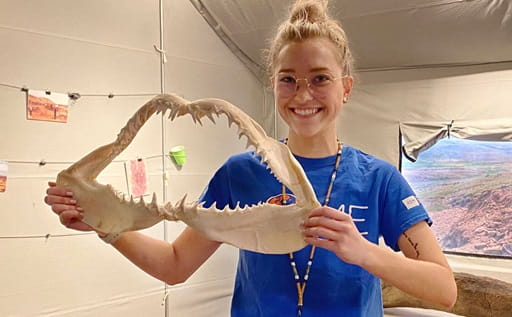 Royal Saskathcewan Museum staff member holds artifact.