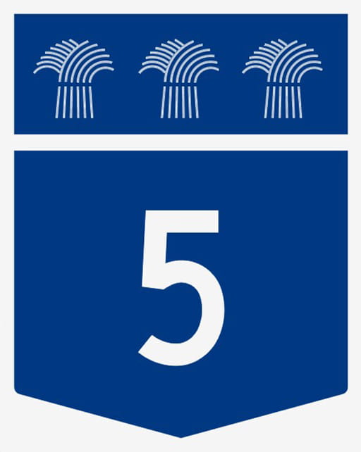 The face of a Highway 5 sign which is a white number 5 on a blue background. Drivers will see it along the route.