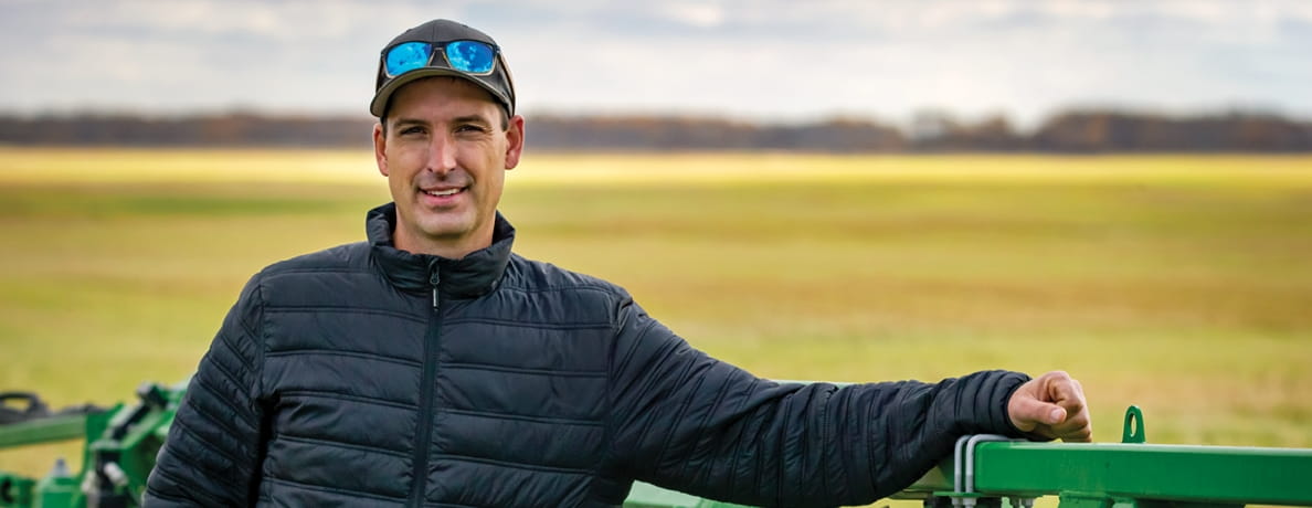 Man smiling at camera with yellow crop in the background