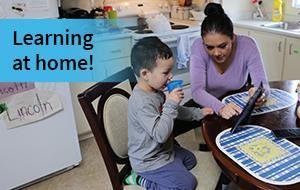 woman reading to boy at table