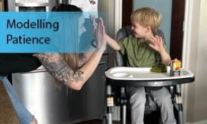 Parent high-fives child sitting in high chair