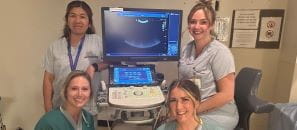 Group of four female health professionals beside ultrasound monitor