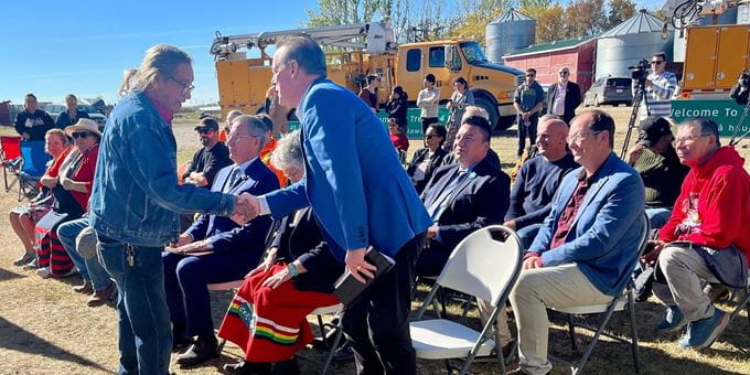 Minister of Government Relations shaking hands with keynote speaker at Treaty Signage event.