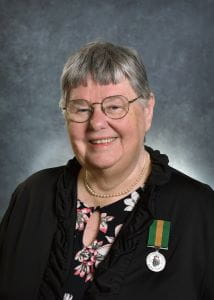 Jayne C.M. Whyte wearing a black suit jacket. The Saskatchewan Volunteer Medal pinned to her jacket. 