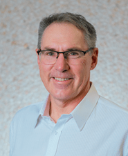 Mr. Dan Rashovich, Ward 1 Councillor for the City of Regina wearing glasses and a light blue shirt with no tie. 